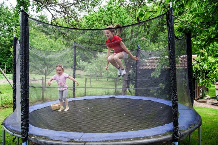 Børn der leger på en rund trampolin